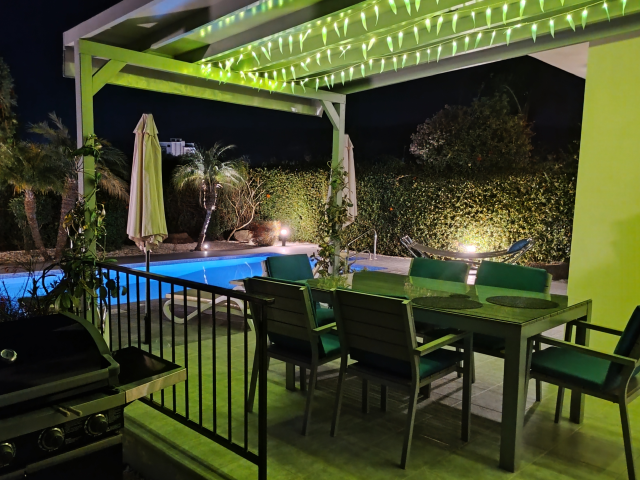 Outdoor dining under green leaf lights